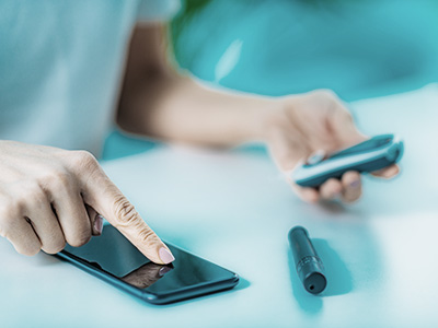 An individual s hand holding a smartphone with a focus on the phone s screen, against a blurred background.